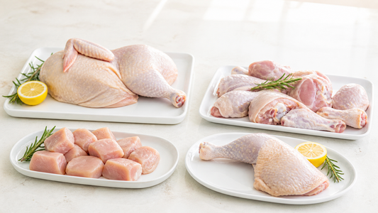 Half chicken, cut chicken pieces, chicken cubes, and a whole chicken leg on bright white plates